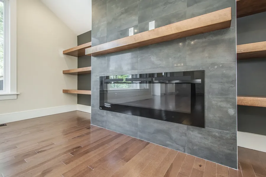 William Borrett Terrace — A custom home photographed at handover — a tiled fireplace wall with floating shelves, a two-tone stair, and a kitchen planned down to its pantry. Designed by MAD Design Interiors in Halifax.